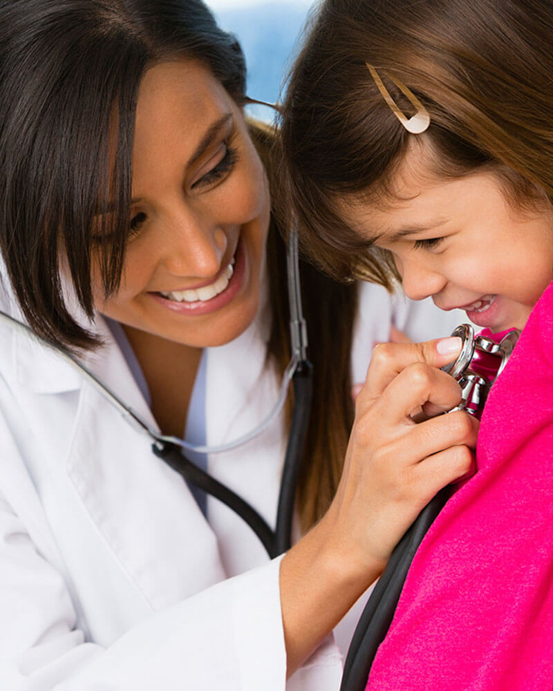 Doctor checking child patient's heart.